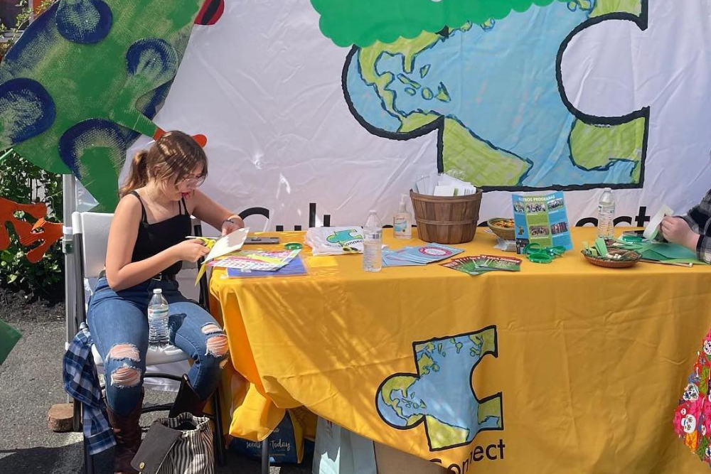Student doing crafts at Culture Connect table at public event.